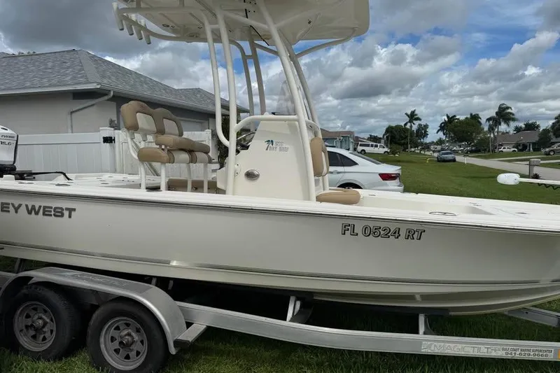 Slide: The Image of 2018 Key West 210 Bay Reef boat on trailer at dealership, cloudy sky background. - 6