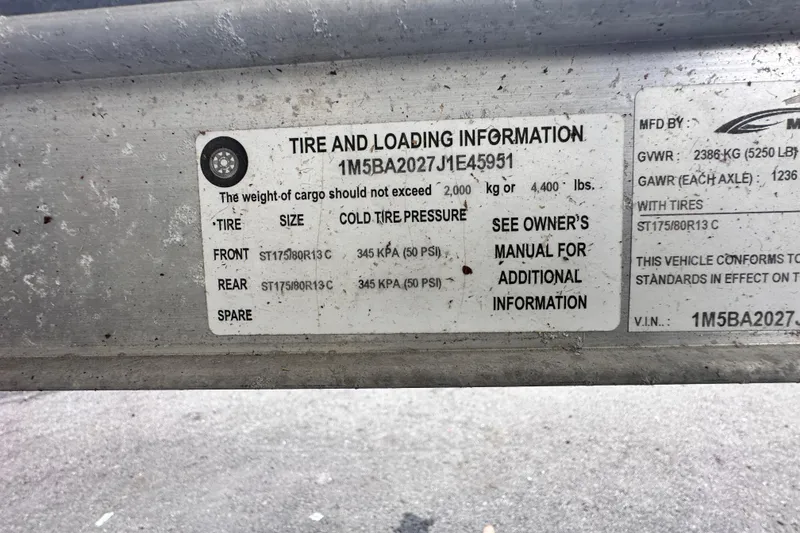 Slide: The Image of Tire and loading information label on a 2018 Key West 210 Bay Reef boat trailer. - 62