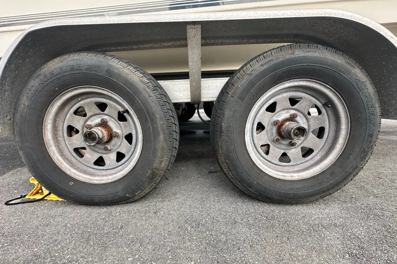 Slide: The Image of Trailer wheels of a 2018 Key West 210 Bay Reef boat on asphalt. - 64