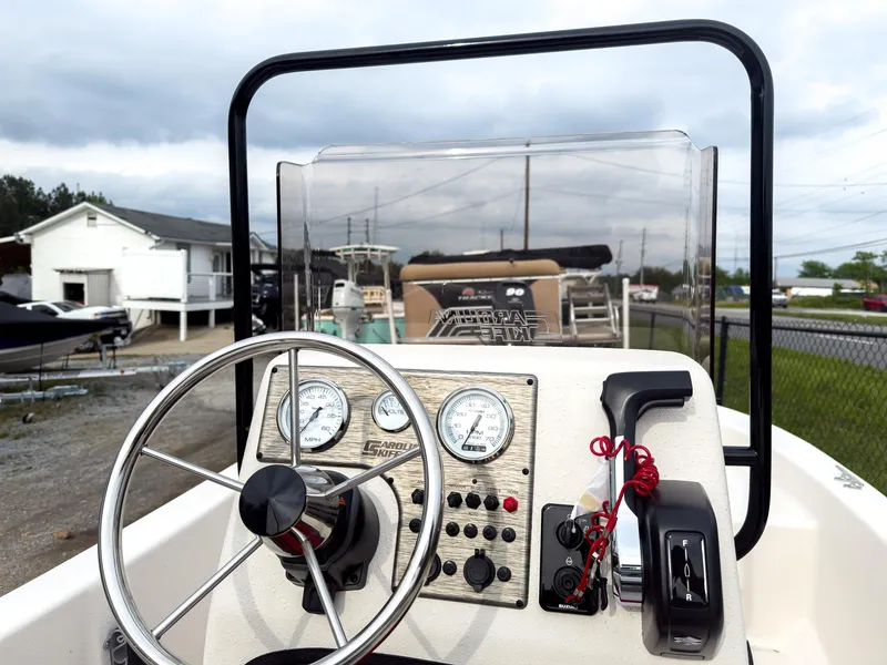 Slide: The Image of 2025 Carolina Skiff 16 JVX CC boat dashboard with steering wheel and gauges. - 4