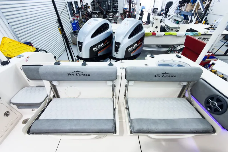 Slide: The Image of 2026 Sea Chaser 27 HFC CC boat interior with McLaren Performance engines in a workshop. - 11