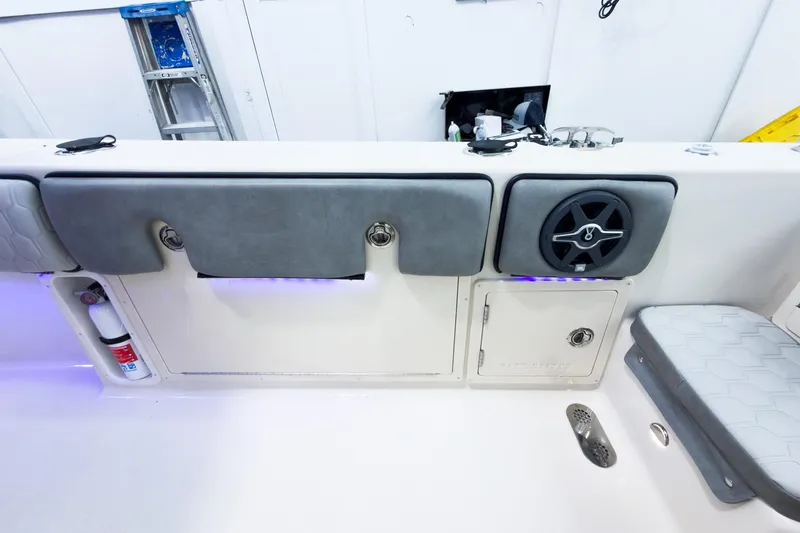 Slide: The Image of 2026 Sea Chaser 27 HFC CC boat interior with storage, speaker, and fire extinguisher. - 14