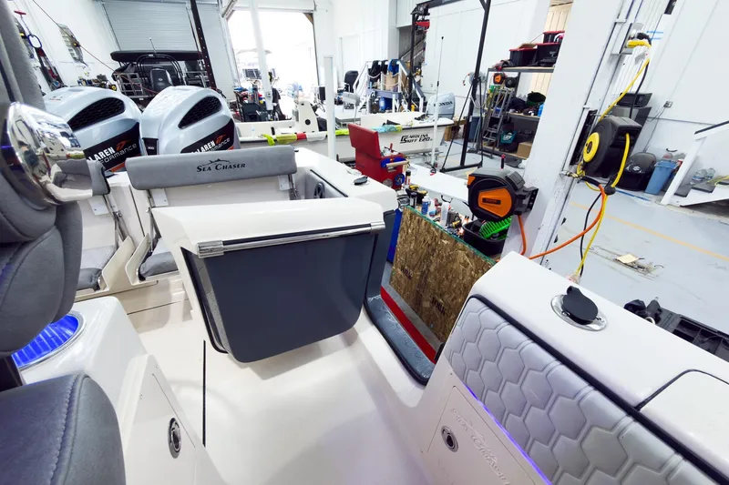 Slide: The Image of 2026 Sea Chaser 27 HFC CC boat interior in a workshop with equipment and tools. - 16
