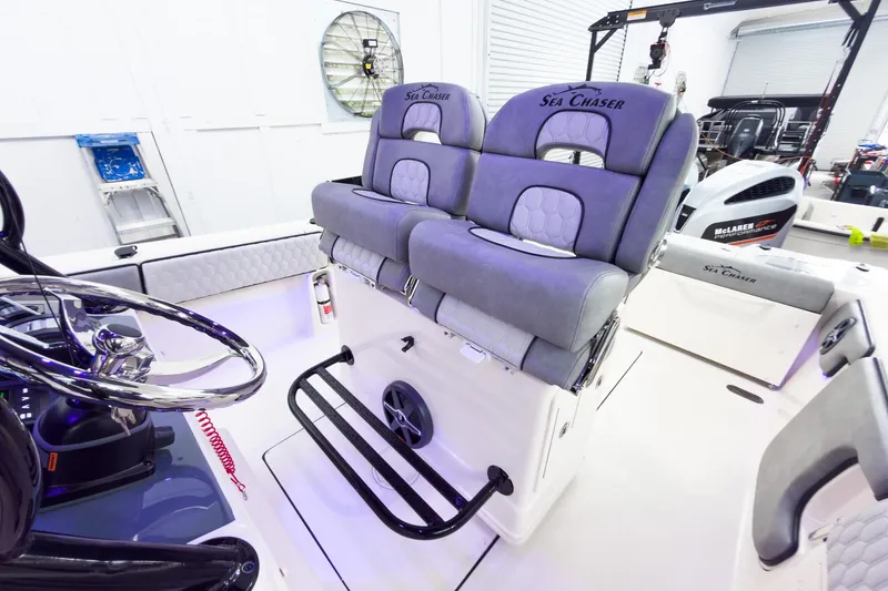 Slide: The Image of 2026 Sea Chaser 27 HFC CC boat interior with dual seats and steering wheel. - 21