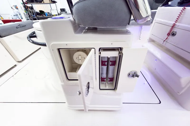 Slide: The Image of 2026 Sea Chaser 27 HFC CC boat interior storage compartment with open doors. - 23