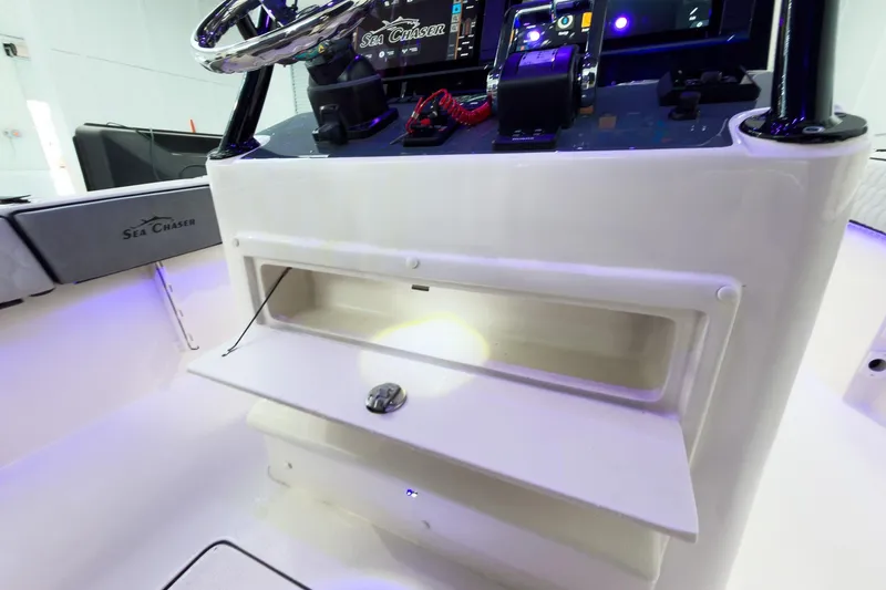 Slide: The Image of 2026 Sea Chaser 27 HFC CC boat console with storage compartment and steering wheel. - 24