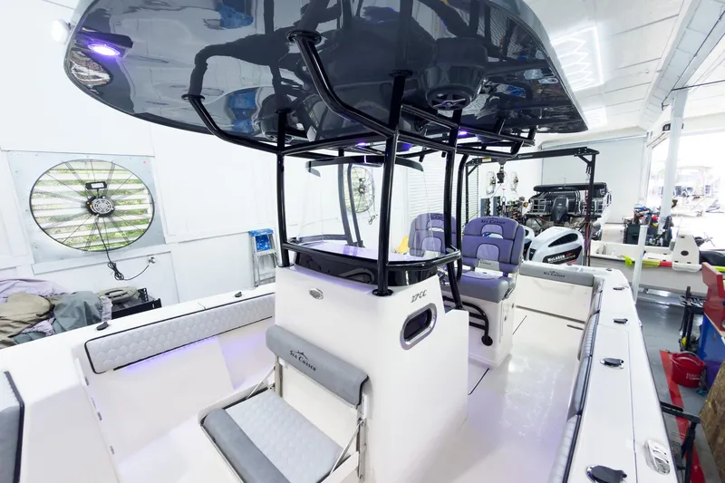 Slide: The Image of 2026 Sea Chaser 27 HFC CC boat interior with modern seating and equipment in a workshop. - 27