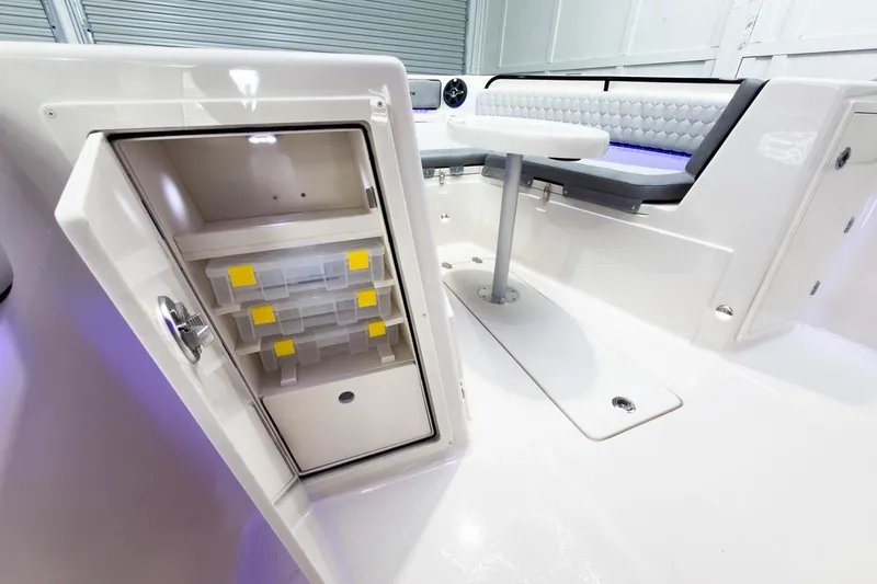 Slide: The Image of 2026 Sea Chaser 27 HFC CC boat interior with storage and seating area. - 33