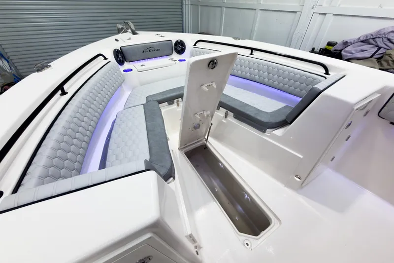 Slide: The Image of 2026 Sea Chaser 27 HFC CC boat interior with cushioned seating and storage compartment. - 37