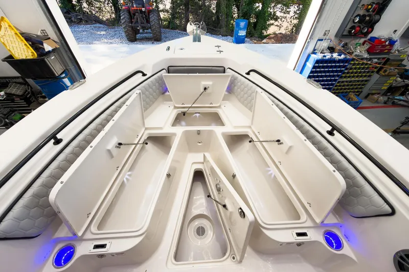 Slide: The Image of 2026 Sea Chaser 22 HFC boat interior with open storage compartments and blue LED lighting. - 10
