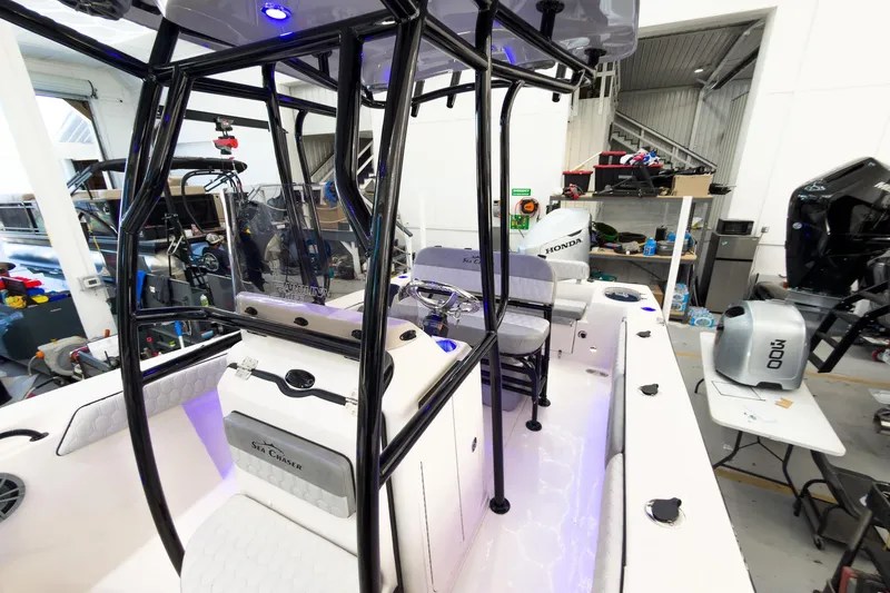 Slide: The Image of 2026 Sea Chaser 22 HFC boat interior with modern seating and equipment in a workshop. - 13