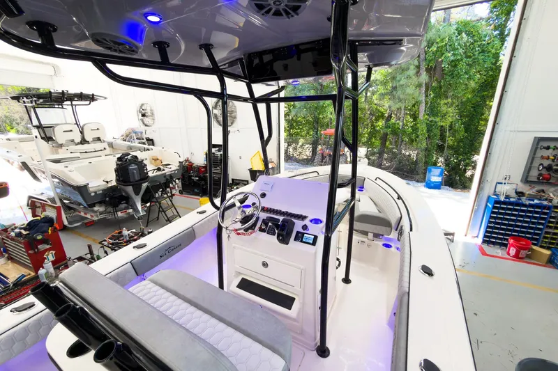 Slide: The Image of 2026 Sea Chaser 22 HFC boat interior in a workshop, featuring modern controls and seating. - 16
