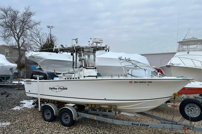 Slide: The Image of 2007 SeaCraft SC 23 Classic boat on trailer, parked outdoors with other boats. - 16