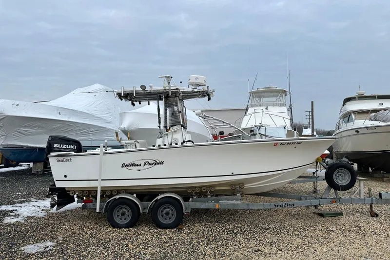 Slide: The Image of 2007 SeaCraft SC 23 Classic boat on trailer, parked in a marina with other boats. - 21