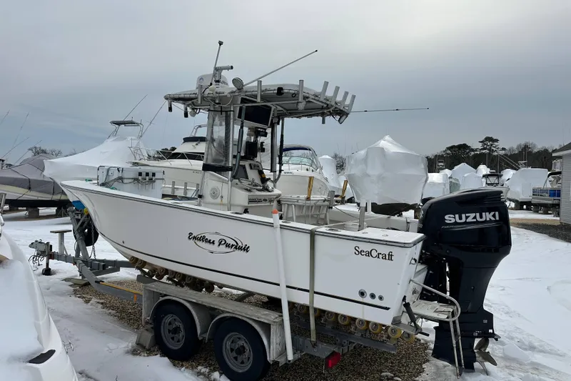 Slide: The Image of 2007 SeaCraft SC 23 Classic boat navigating a calm marina with docks. - 5
