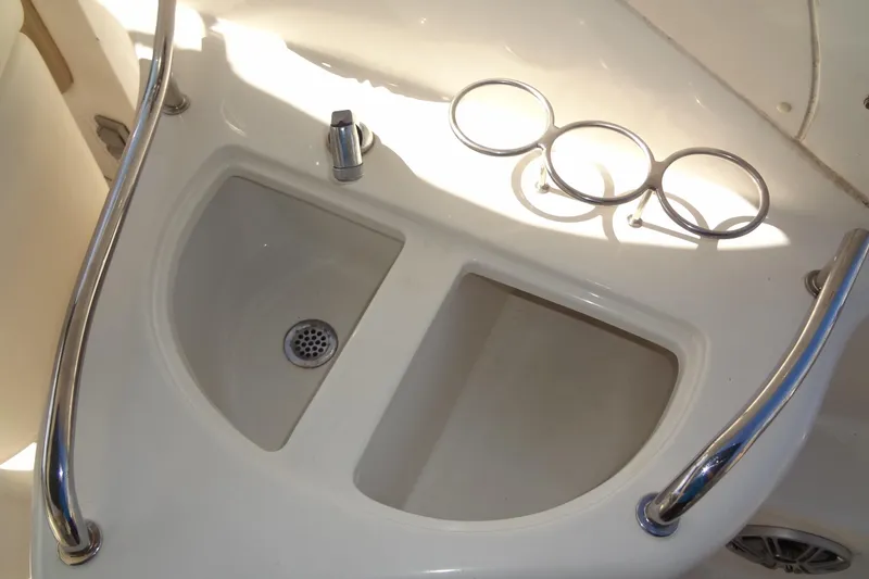 Slide: The Image of 2002 Sea Ray Sundancer 280 boat sink with metal railings and cup holders. - 20