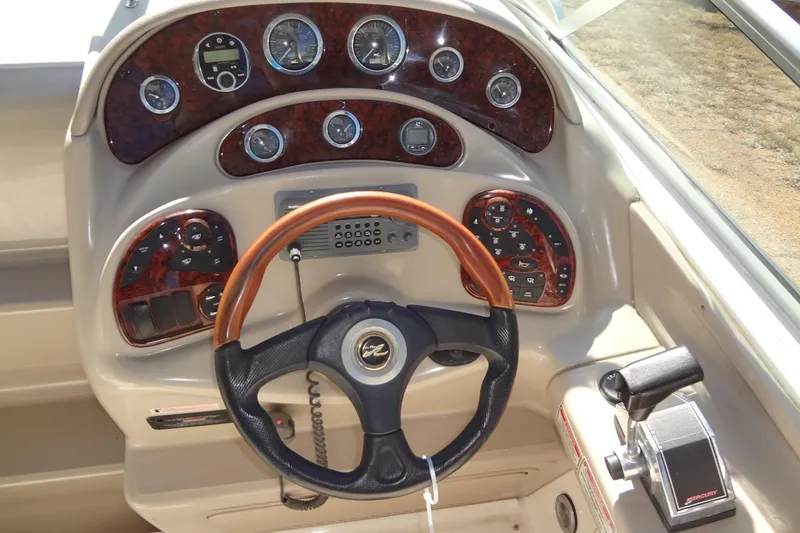 Slide: The Image of 2002 Sea Ray Sundancer 280 dashboard with wood accents and steering wheel. - 23