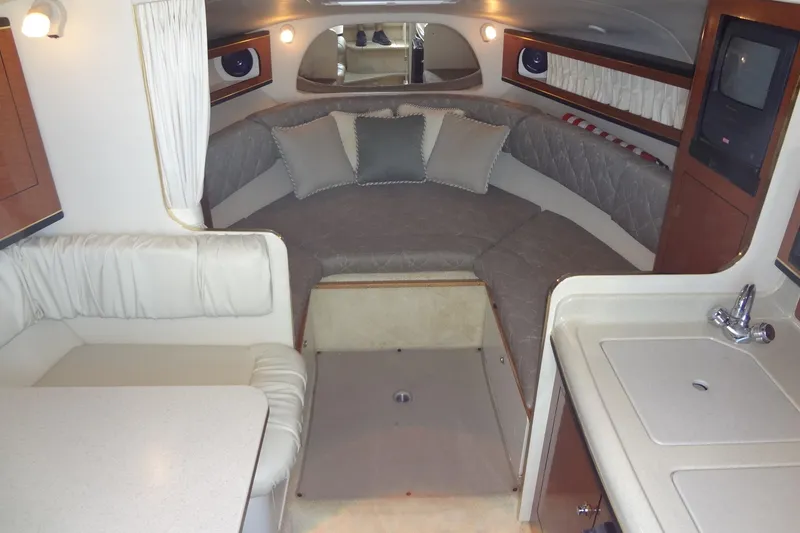 Slide: The Image of Interior of 2002 Sea Ray Sundancer 280 with cozy seating and kitchenette. - 26