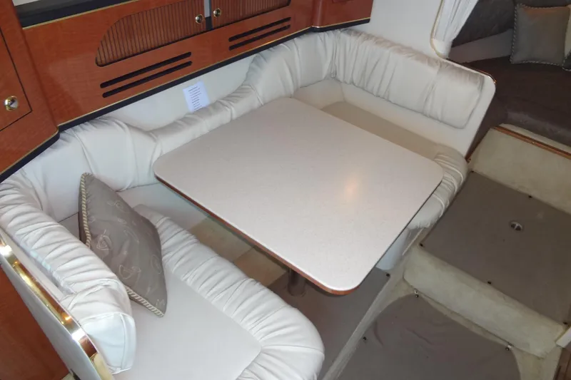 Slide: The Image of Interior of 2002 Sea Ray Sundancer 280 with cozy dining area and cushioned seating. - 27
