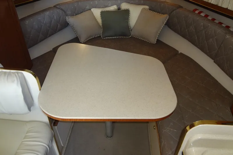 Slide: The Image of Interior of 2002 Sea Ray Sundancer 280 with cushioned seating and table. - 30