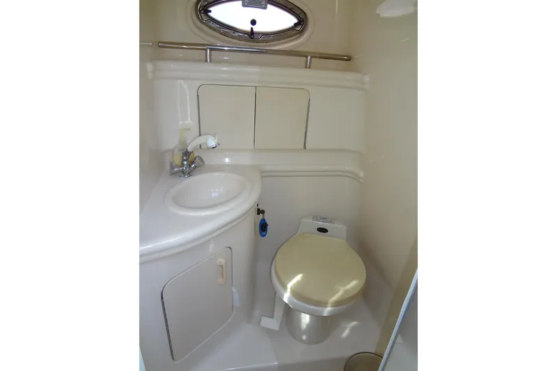 Slide: The Image of 2002 Sea Ray Sundancer 280 bathroom with sink, toilet, and oval window. - 36