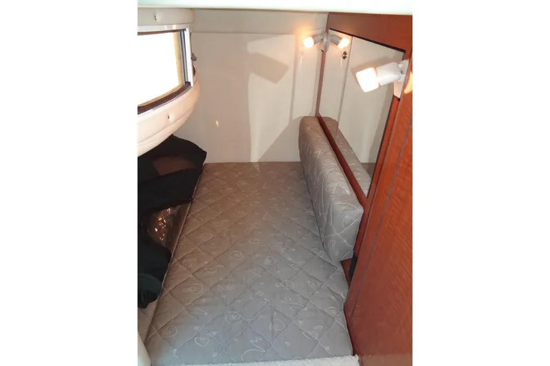 Slide: The Image of 2002 Sea Ray Sundancer 280 cabin interior with bed, lighting, and wood accents. - 38