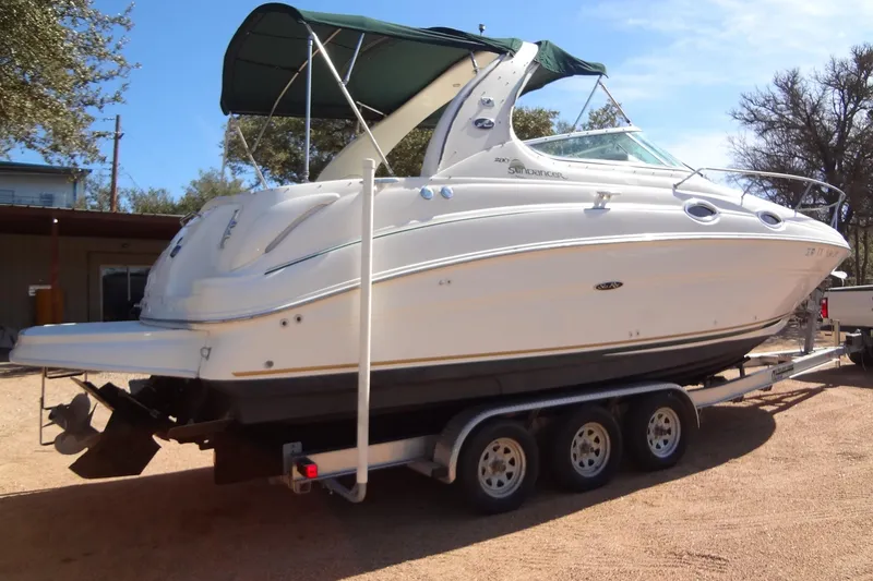 Slide: The Image of 2002 Sea Ray Sundancer 280 boat on trailer, parked outdoors under clear sky. - 5