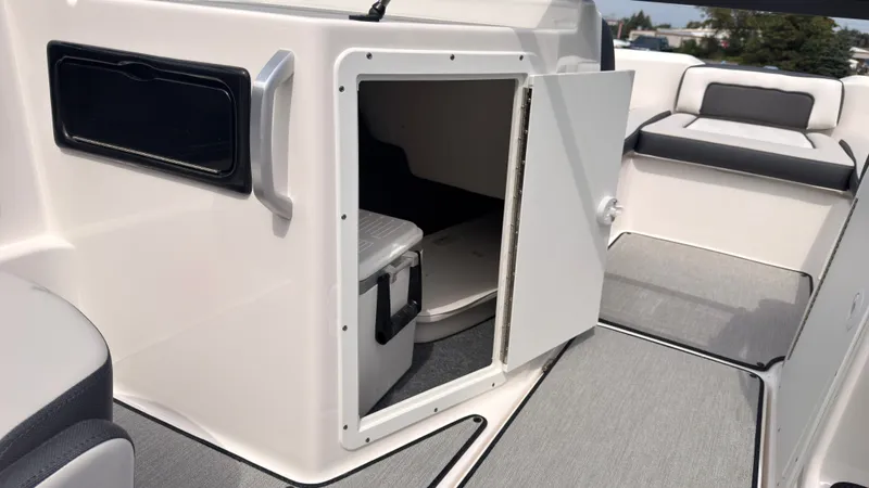 Slide: The Image of The image shows the storage area of a 2026 Yamaha SX195 boat with a cooler inside. - 21
