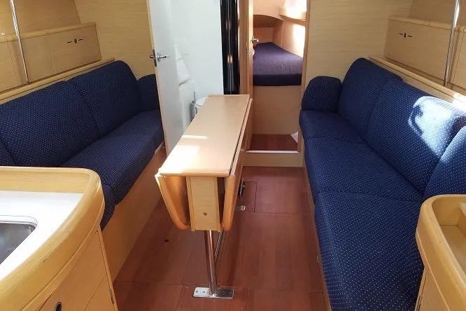 Slide: The Image of Interior of 2010 Beneteau First 36.7 yacht with blue seating and wooden finishes. - 3