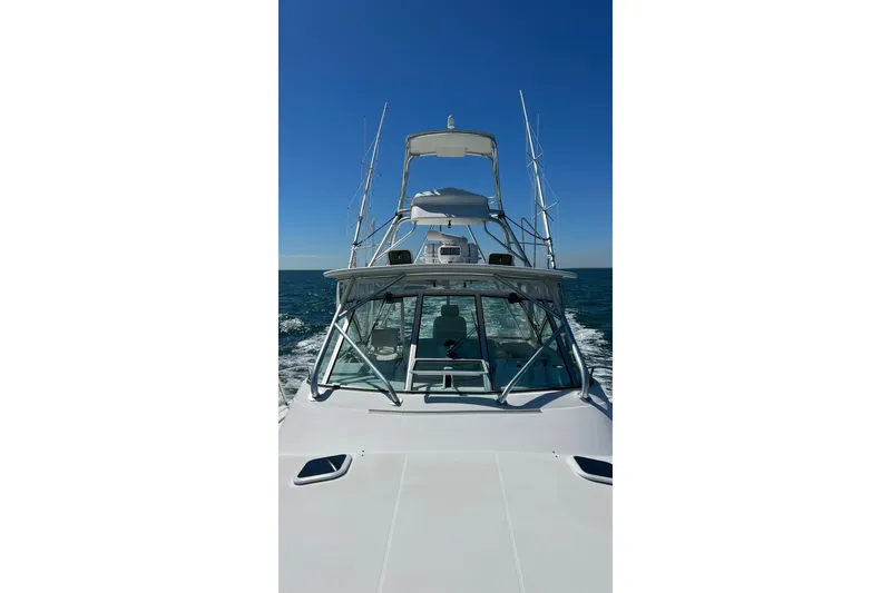 Slide: The Image of 2005 Rampage 38 Express boat cruising on open sea under clear blue sky. - 16