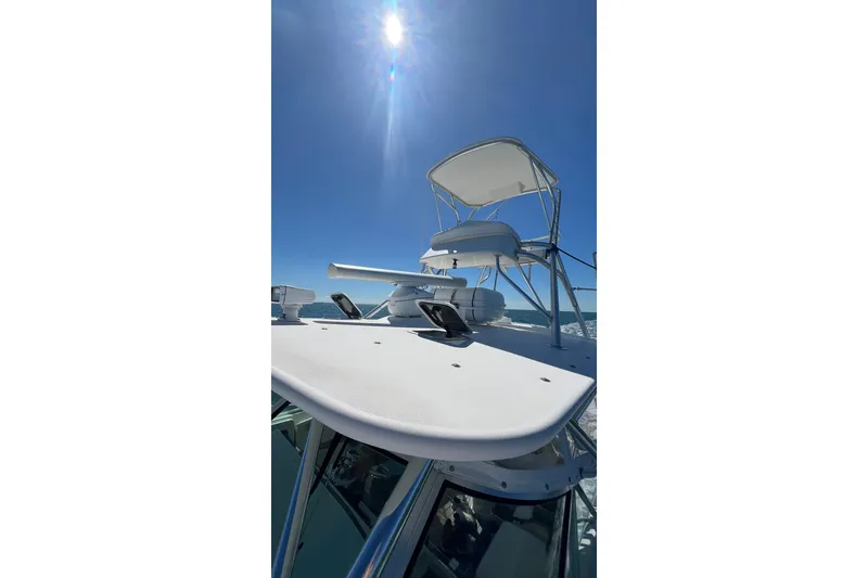 Slide: The Image of 2005 Rampage 38 Express boat under clear blue sky with sun overhead. - 17