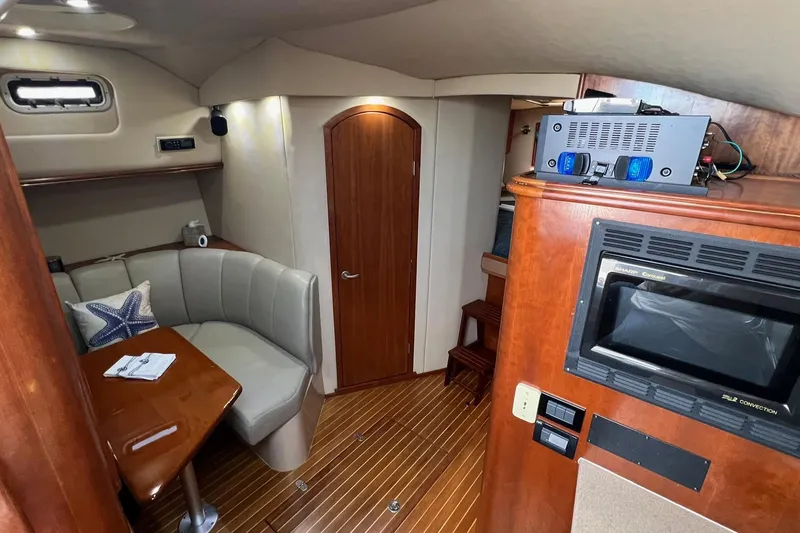 Slide: The Image of 2005 Rampage 38 Express cabin interior with seating, table, and microwave. - 19