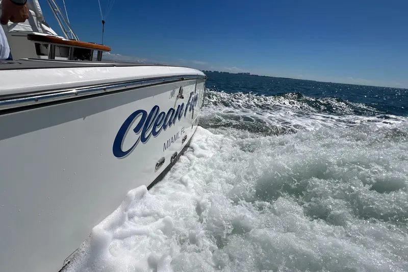 Slide: The Image of 2005 Rampage 38 Express boat cruising through ocean waves under clear blue sky. - 2