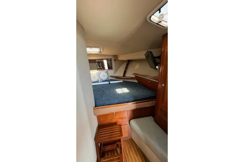Slide: The Image of 2005 Rampage 38 Express cabin interior with bed, wooden accents, and natural light. - 22