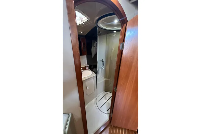 Slide: The Image of 2005 Rampage 38 Express yacht bathroom with shower, sink, and wooden door. - 24