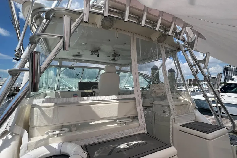 Slide: The Image of 2005 Rampage 38 Express boat interior with helm, marina view, and clear skies. - 31