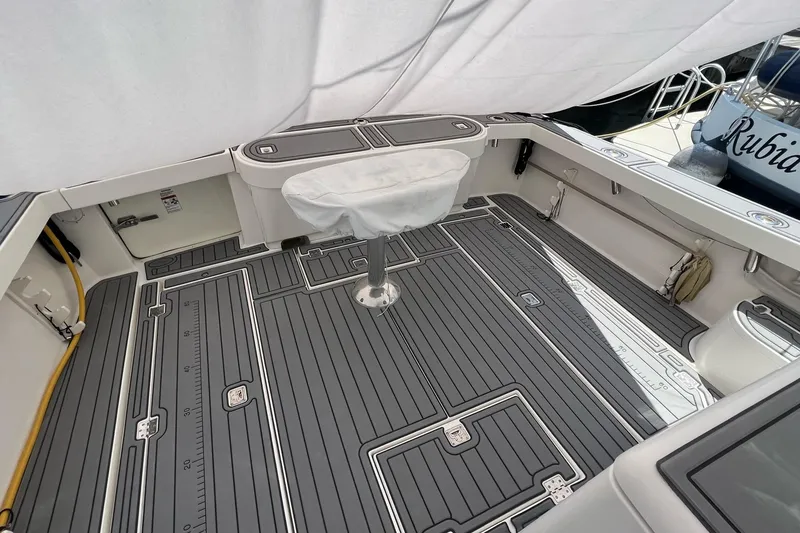 Slide: The Image of 2005 Rampage 38 Express boat deck with gray non-slip flooring and covered seating. - 32