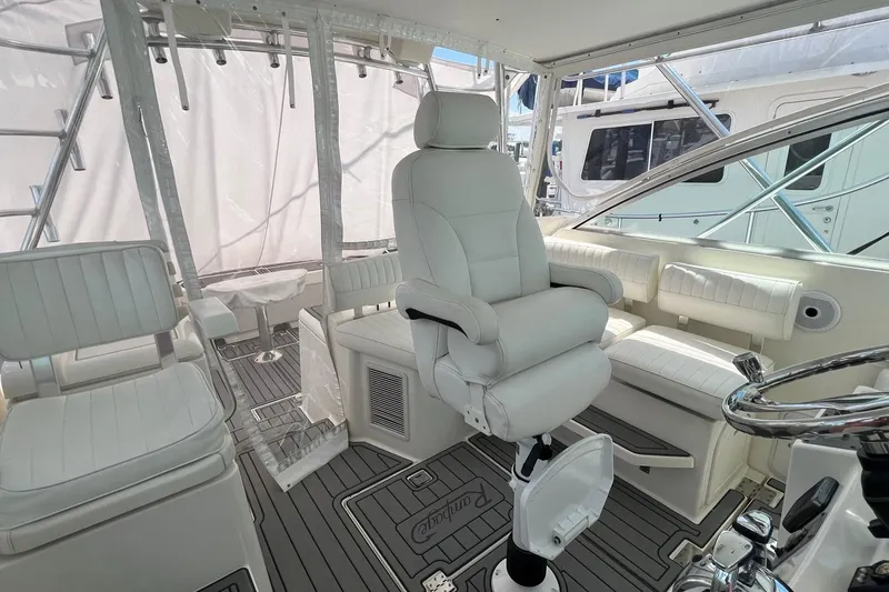Slide: The Image of Luxurious interior of 2005 Rampage 38 Express boat with white seating and helm. - 34