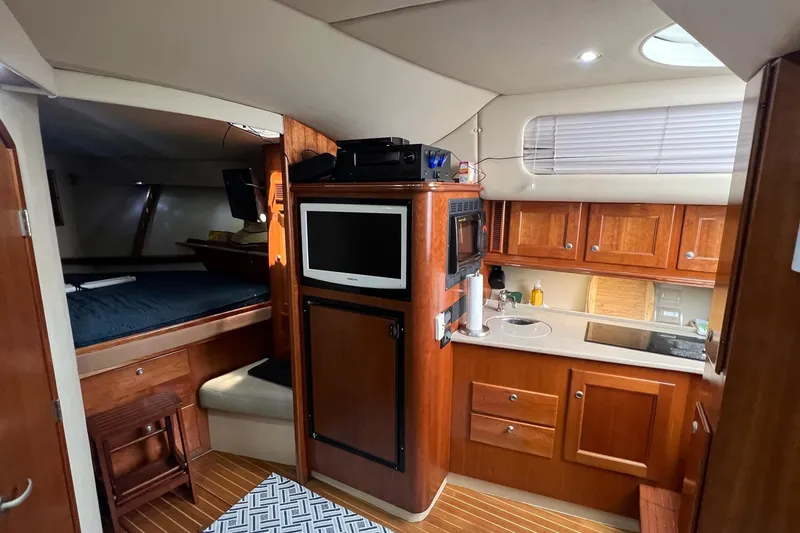 Slide: The Image of 2005 Rampage 38 Express yacht interior with wood cabinetry, kitchenette, and cozy sleeping area. - 37