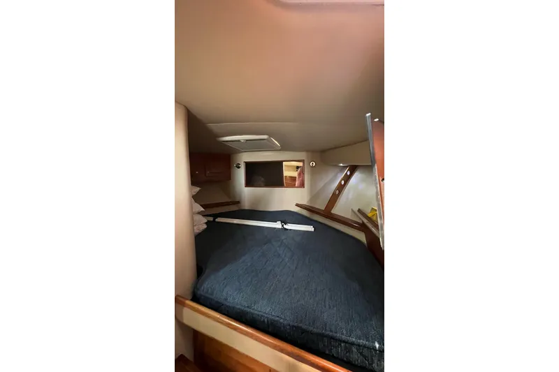 Slide: The Image of 2005 Rampage 38 Express cabin interior with bed and wooden accents. - 38