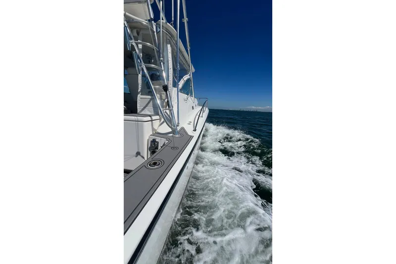 Slide: The Image of 2005 Rampage 38 Express cruising on open water under clear blue skies. - 9