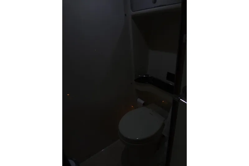 Slide: The Image of Dimly lit bathroom interior of 2010 Formula 45 Yacht, featuring a toilet and storage space. - 72