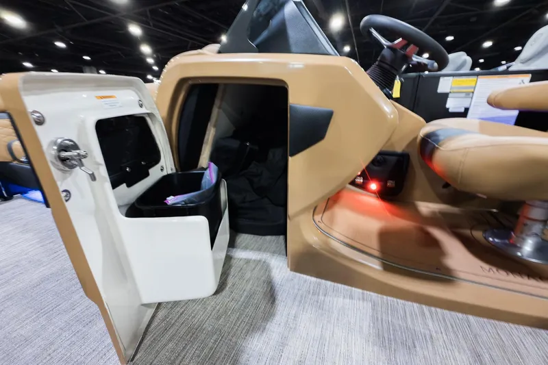 Slide: The Image of 2026 Godfrey Monaco 235 Ultra Lounge interior with open storage compartment and steering wheel. - 16