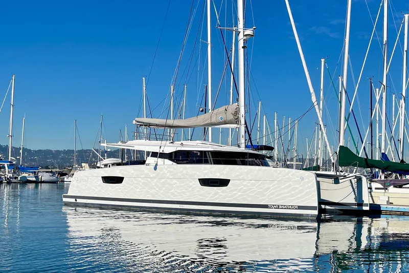 The Image of 2018 Fountaine Pajot Saona catamaran docked in a marina under clear blue skies. - 0