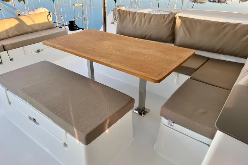 Slide: The Image of 2018 Fountaine Pajot Saona yacht with elegant outdoor seating and wooden table. - 10