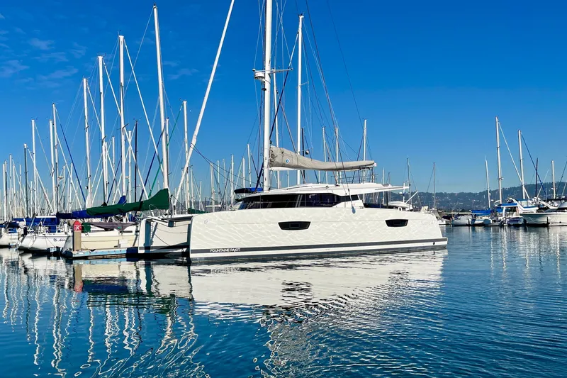 Slide: The Image of 2018 Fountaine Pajot Saona catamaran docked in a marina under clear blue skies. - 21