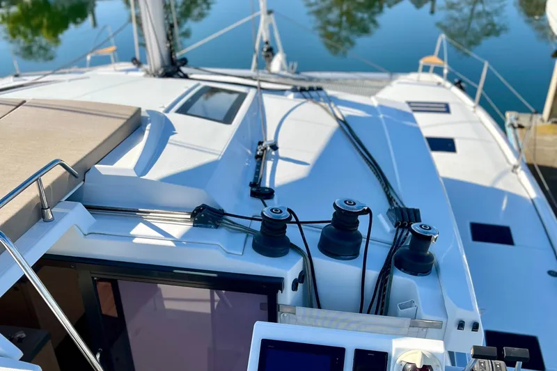 Slide: The Image of 2018 Fountaine Pajot Saona catamaran deck with winches and ropes, docked by calm water. - 5