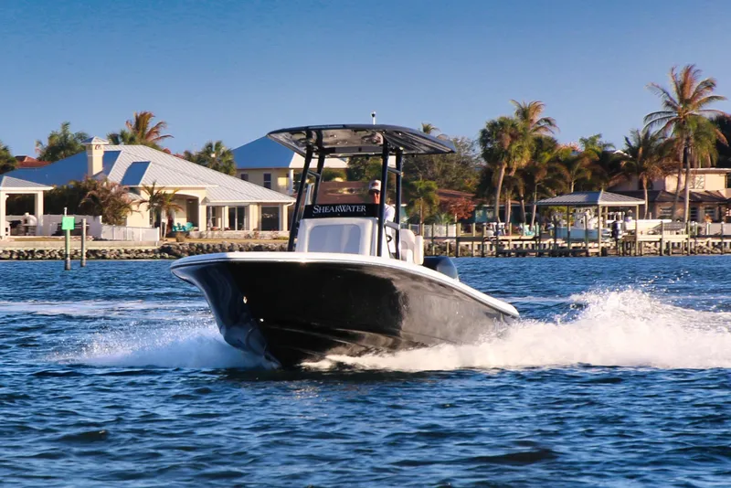 Slide: The Image of 2023 ShearWater 260 SS Carolina boat cruising on a sunny waterfront. - 7