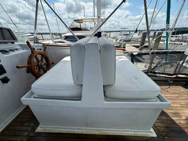 Slide: The Image of 1974 Grand Banks 32 Sedan boat interior with white seating and wooden steering wheel. - 11
