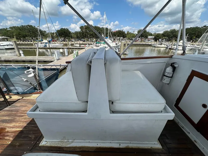 Slide: The Image of 1974 Grand Banks 32 Sedan boat interior with white seating at a marina. - 12